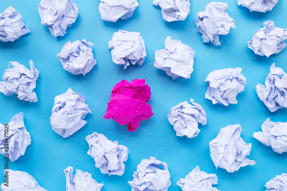 Naklejka premium White with pink crumpled paper balls on a blue background.