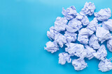 White crumpled paper balls on a blue background.