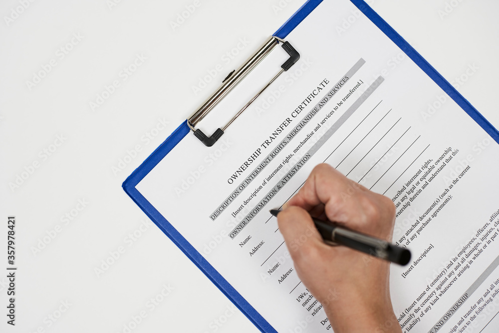 A person filling ownership transfer certificate document A person filling ownership transfer certificate document