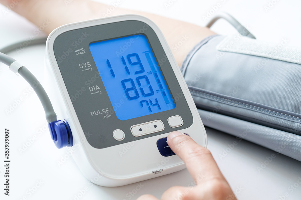 Man check blood pressure monitor and heart rate monitor with digital pressure gauge. Health care and Medical concept Man check blood pressure monitor and heart rate monitor with digital pressure gauge. Health care and Medical concept