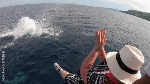 Dolphins jumping out of water, tourist enjoying at the moment photo