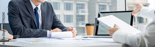 Fotografie Businesspeople discussing project at the meeting table in city office, panoramic
