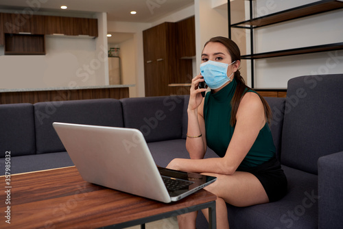 Mujer con cubre bocas trabajando en casa debido a la nueva normalidad por la pandemia de covid-19