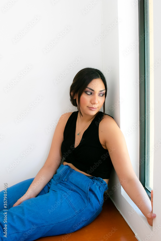 Mujer observando la ventana desde un cuarto Mujer observando la ventana desde un cuarto
