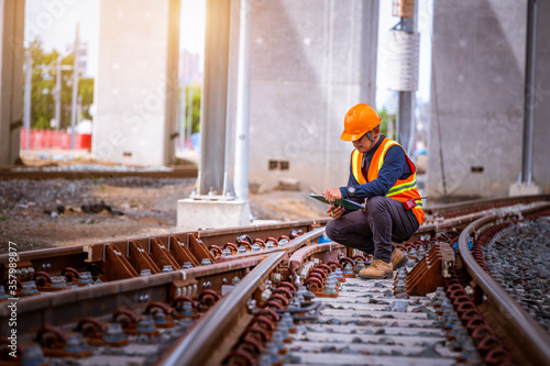 Obraz na plátně Engineer under inspection and checking construction process railway switch and checking work on railroad station