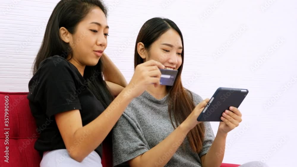 Two young woman who are friends using computer tablet for shopping online with credit card. Two young woman who are friends using computer tablet for shopping online with credit card.