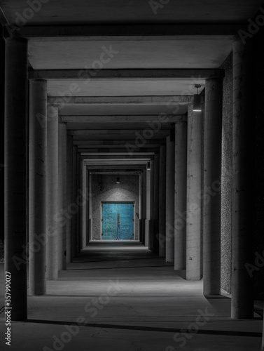 Greek-style dark corridor to turquoise doors 