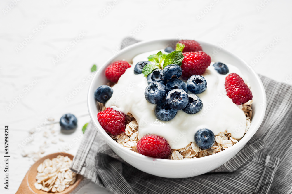 Breakfast, oatmeal with blueberry and raspberry on white bowl in the morning. Breakfast, oatmeal with blueberry and raspberry on white bowl in the morning.