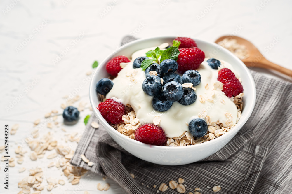 Breakfast, oatmeal with blueberry and raspberry on white bowl in the morning. Breakfast, oatmeal with blueberry and raspberry on white bowl in the morning.