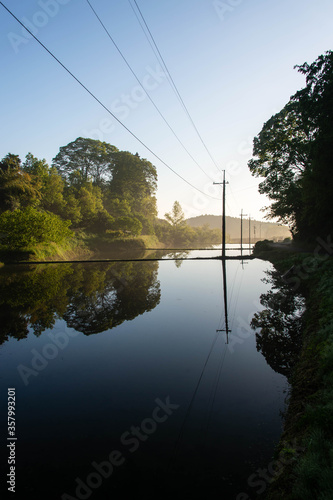 静かな水面に映り込む電線 © sigmaphoto