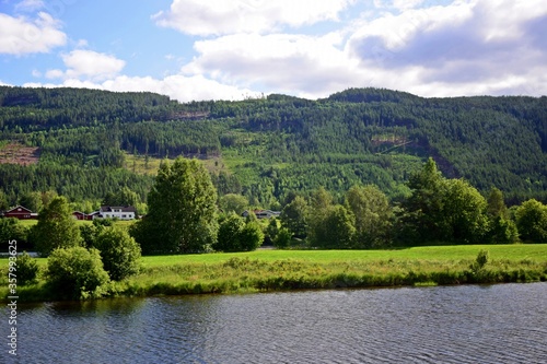 Beautiful Norway forest landscape with green mountain and blue lake in a summer sunny day