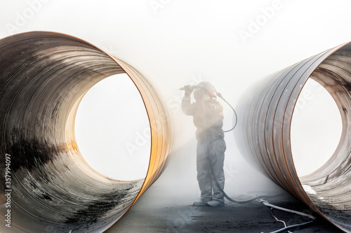View of sandblasting before coating. Abrasive blasting, more commonly known as sandblasting, is the operation of forcibly propelling a stream of abrasive material against a surface. photo