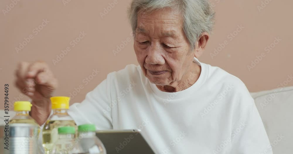 Senior woman using tablet to check product price at home. She compare product price in tablet. Senior woman using tablet to check product price at home. She compare product price in tablet.