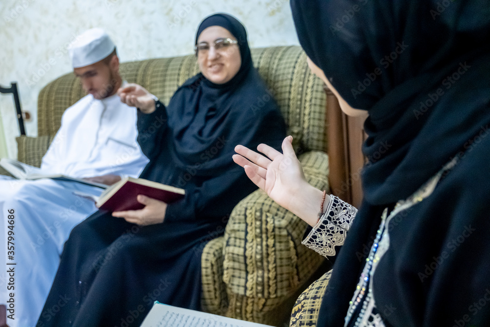Happy muslim family reading books together and discussing ideas