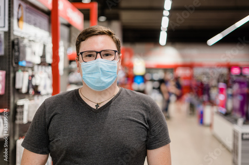 Caucasian man shopping for clothes with medical mask. New normal concept. 