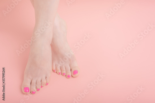 Fototapeta Naklejka Na Ścianę i Meble -  beautiful well groomed female legs with bright pedicure on a pink background, copy space