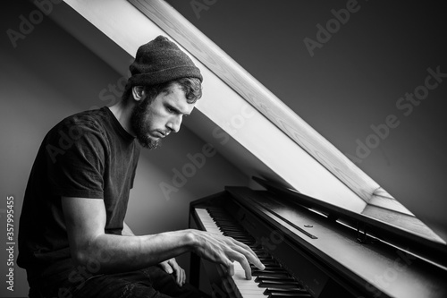 Canvas Print Musician and composer in a hat plays piano, black and white, The pianist perform