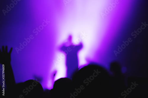 silhouette of a vocalist of a musical group on stage in the light of spotlights.