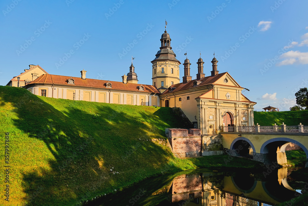 Exterior of a medieval castle. View of an old castle with a fortress wall and a moat with water.