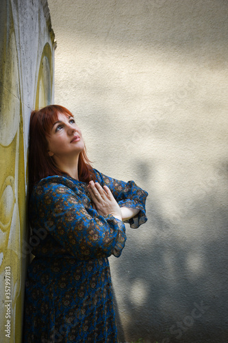 Beautiful attractive adult middle aged woman praying outdoors
