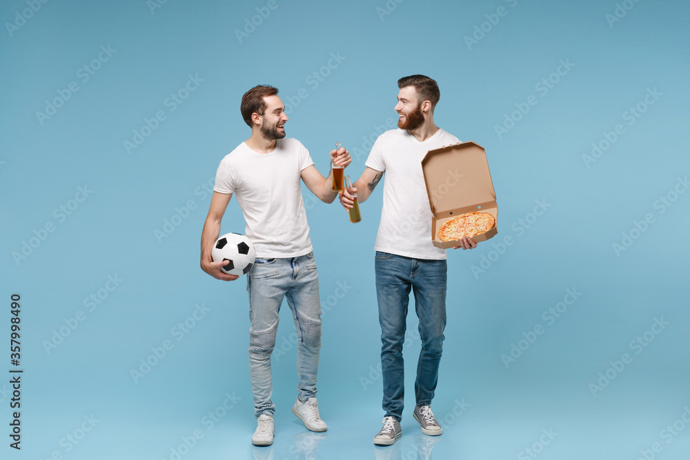 Funny men guys friends in white t-shirt isolated on pastel blue background. Sport leisure concept. Cheer up support favorite team with soccer ball, beer bottle, italian pizza in cardboard flatbox.