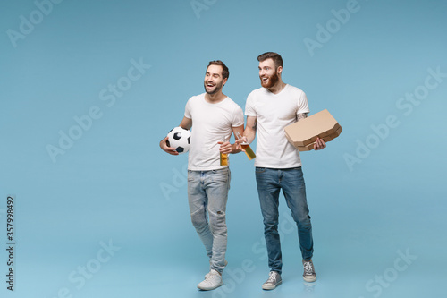 Cheerful men guys friends in white t-shirt isolated on pastel blue background. Sport leisure concept. Cheer up support favorite team with soccer ball, beer bottle, italian pizza in cardboard flatbox.