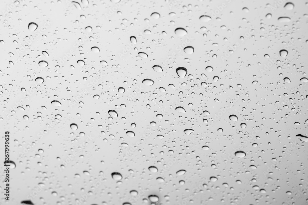 White drops of rain on a window glass in the city. Image of raindrops texture background. White drops of rain on a window glass in the city. Image of raindrops texture background.