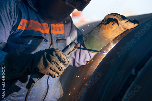 Foto Shielded metal arc welding, manual metal arc weld, flux shielded arc weld or stick welding, is a manual arc welding process that uses a consumable electrode covered with a flux to lay the weld