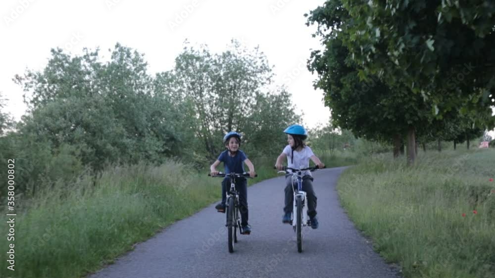 Children, boys, riding bikes together summer time on a rainy day Children, boys, riding bikes together summer time on a rainy day