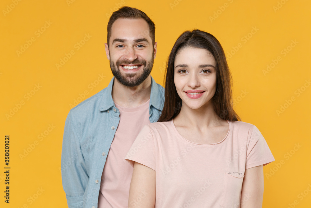 Smiling young couple two friends guy girl in pastel blue casual clothes posing isolated on yellow background studio portrait. People emotions lifestyle concept. Mock up copy space. Looking camera. Smiling young couple two friends guy girl in pastel blue casual clothes posing isolated on yellow background studio portrait. People emotions lifestyle concept. Mock up copy space. Looking camera.