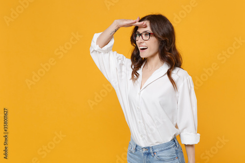 Obraz na plátně Excited young business woman in white shirt glasses isolated on yellow background