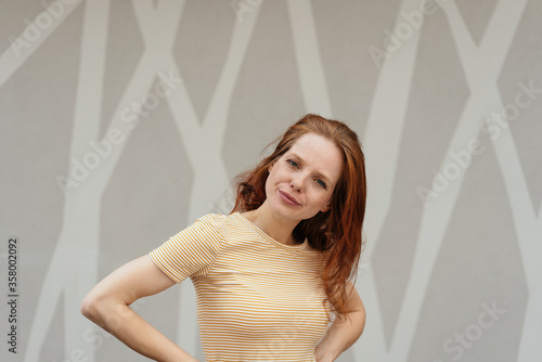 Puzzled young woman standing with hands on hips