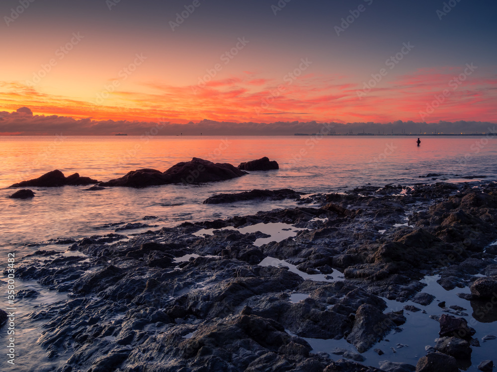 Beautiful Seaside Sunrise with Man Fishing