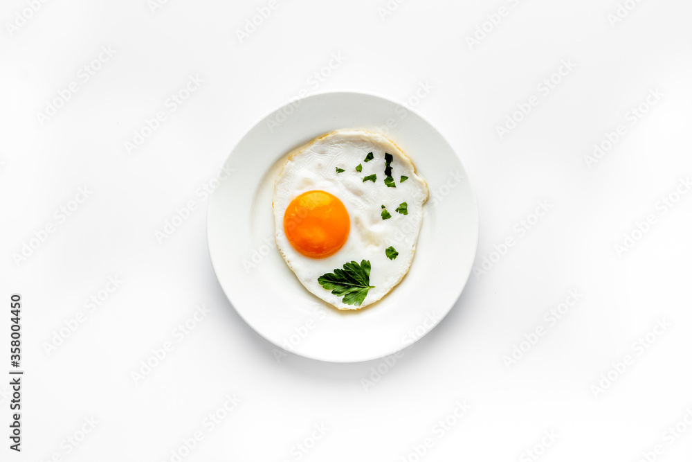 Fried eggs on plate - white kitchen table top-down Fried eggs on plate - white kitchen table top-down