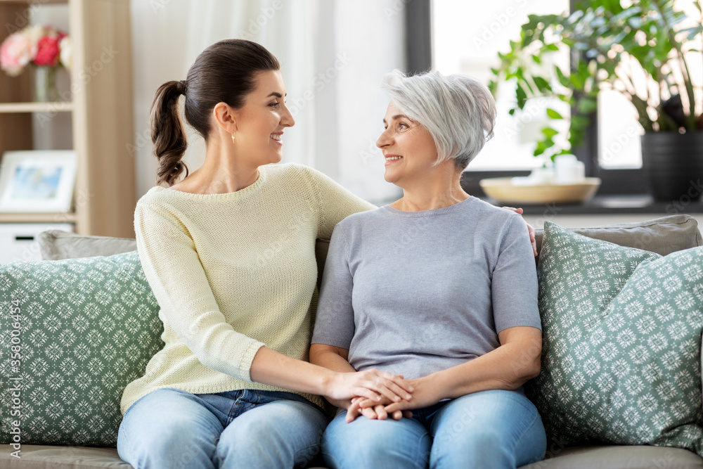 family, generation and people concept - happy smiling senior mother with adult daughter hugging at home family, generation and people concept - happy smiling senior mother with adult daughter hugging at home