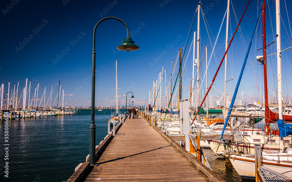 Pier in Melbourne, Australia. Pier with boats. Harbor in a city suburb, peaceful water. Great weather day and boats for sail.