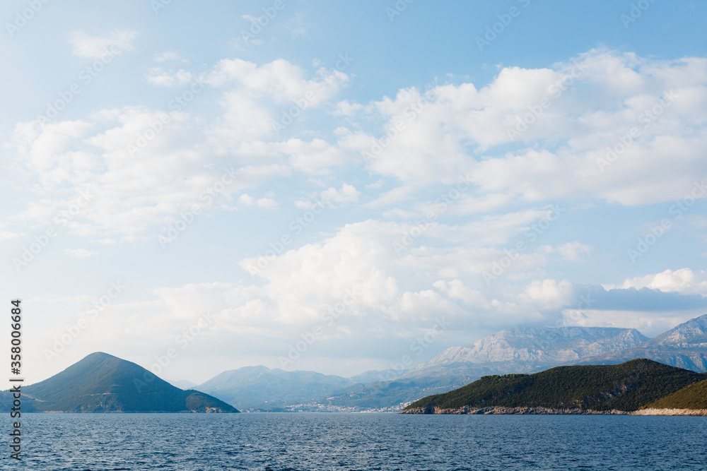Sea and rocky mountains on the border of Montenegro and Croatia, White clouds on the blue sky.