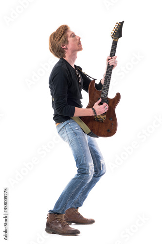 Passionate hard rocker man playing electric guitar with emotions with closed eyes. Full body length isolated on white background. 