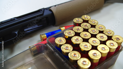 Shotgun on Table with shotgun cartridge shells in Box, shooting range.