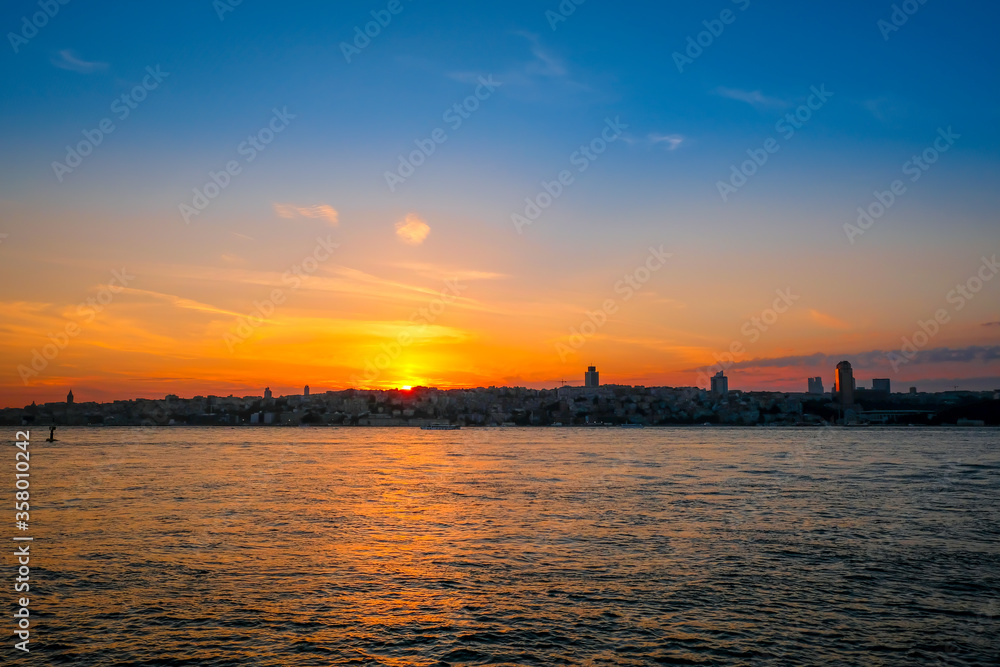 Beautiful sunset over the Bosphorus Bridge, Istunbul, Turkey. Silhouette of resort town.