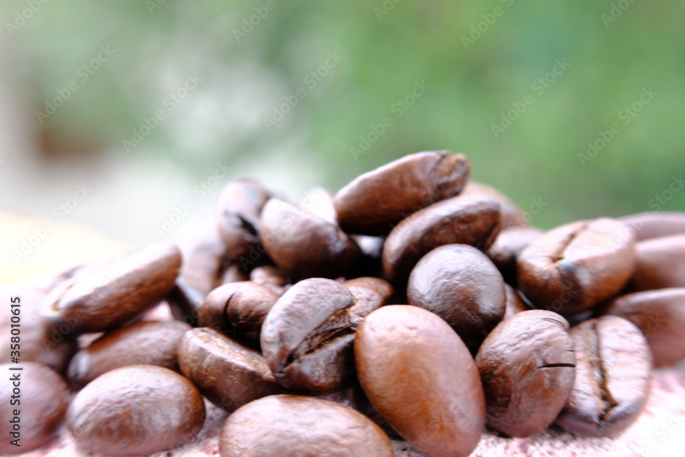 Fototapeta premium close up coffee beans on wood table and macro coffee beans background