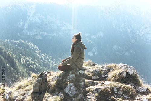 Fotografie Girl meditates on top of a mountain