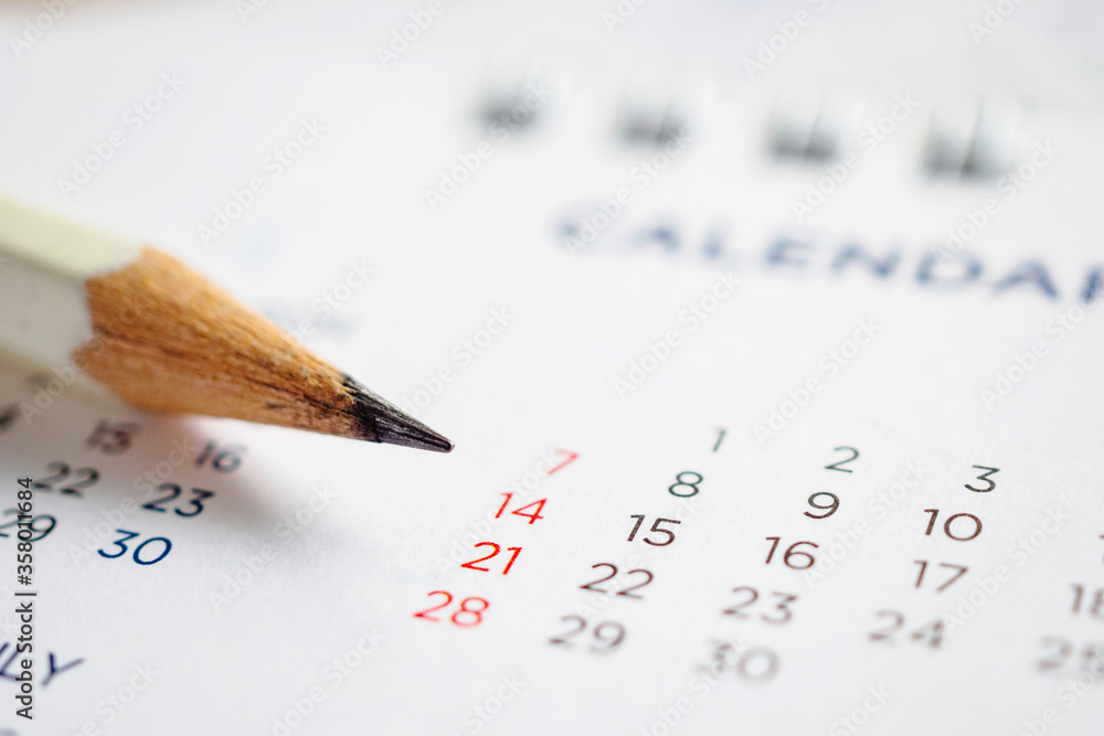 Close up pencil on calendar page to mark the date planning concept Close up pencil on calendar page to mark the date planning concept