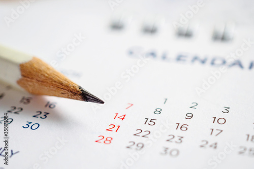 Close up pencil on calendar page to mark the date planning concept