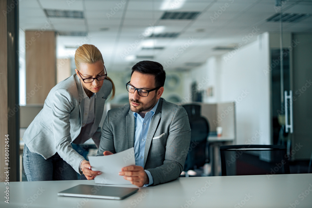 Portrait of a business partners discussing over document in the office, copy space. Portrait of a business partners discussing over document in the office, copy space.