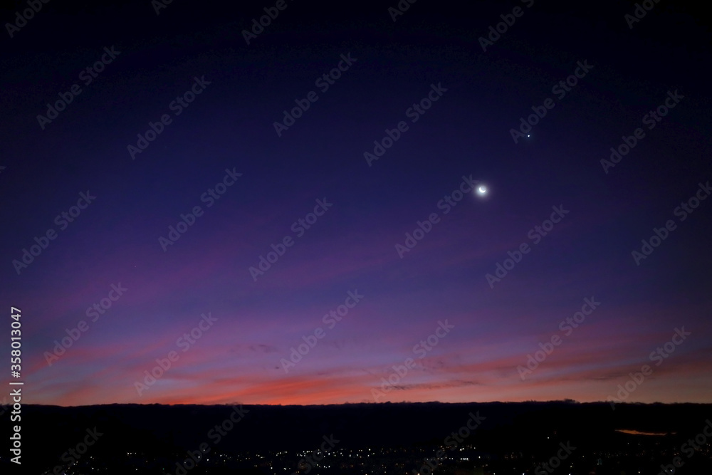 Beautiful purple sunset with the moon in the sky. Generous Ramadan. Dawn and sunset.