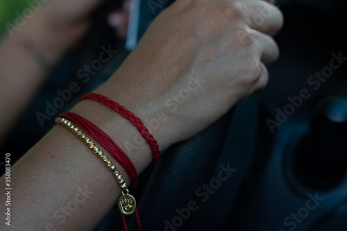 woman hands with armbands grabbing automobile steering wheel