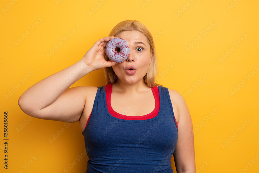 Fat girl eats sweet instead of do gym. Cyan background Fat girl eats sweet instead of do gym. Cyan background