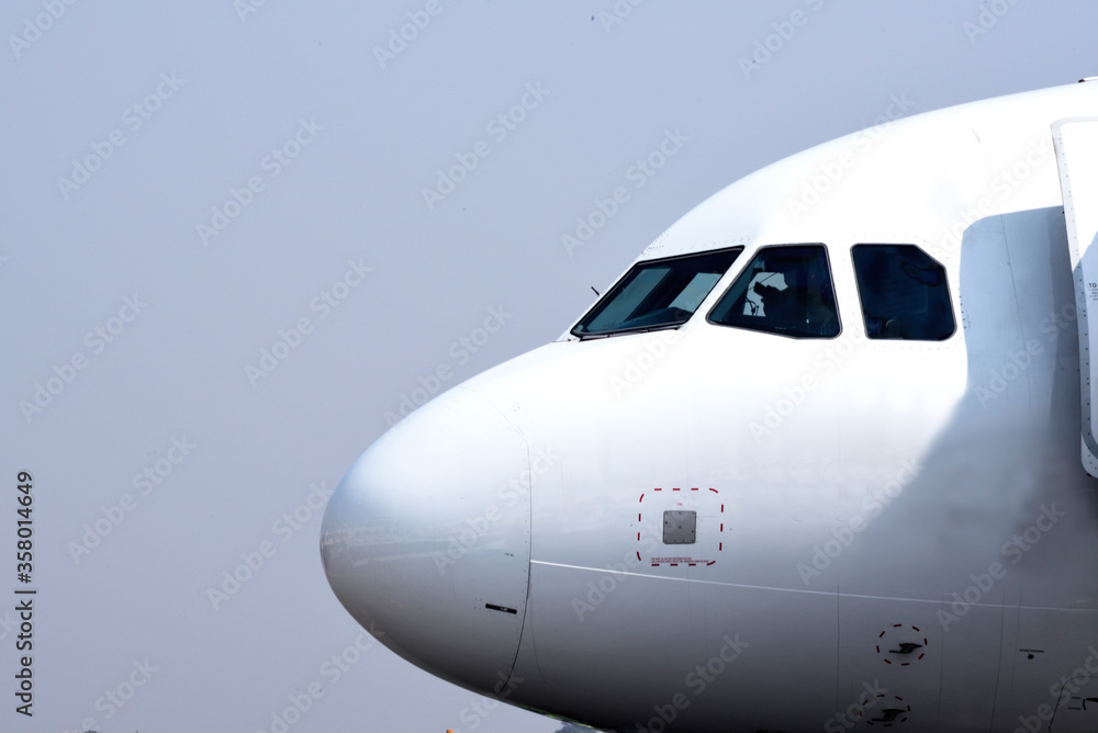 Close-up of airplane nose against blue sky background. Close-up of airplane nose against blue sky background.