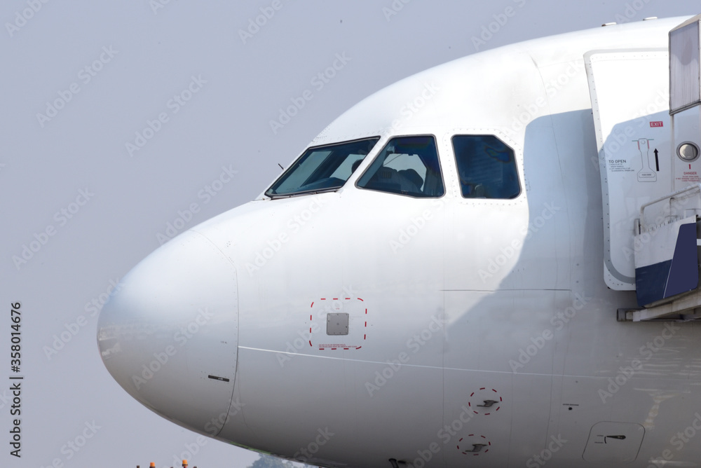 Close-up of airplane nose against blue sky background. Close-up of airplane nose against blue sky background.